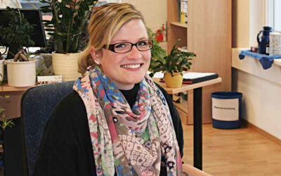 Eine junge Frau lächelt in die Kamera.