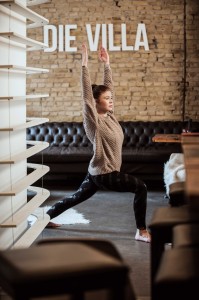 Eine junge Frau performt eine Yoga-Figur.