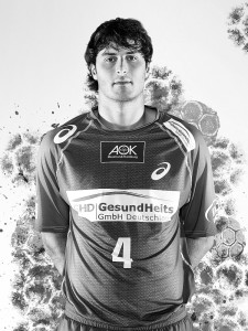 Ein Mann schaut in einem Handballtrikot in die Kamera. 
