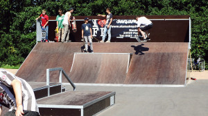 Auf einer Skate-Rampe stehen junge Leute mit Skateboards.