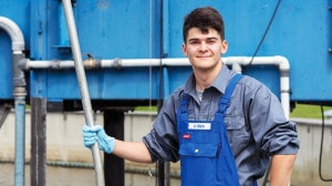Klärwerk Hetlingen: Ein junger Mann in blauer Arbeitskleidung.