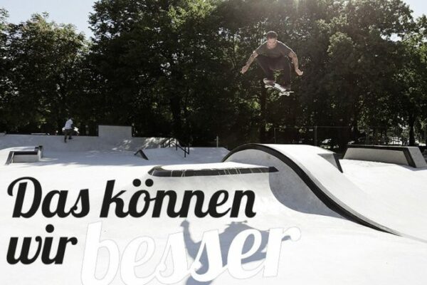 Ein Mann Sprint mit einem Skateboard über eine Rampe.