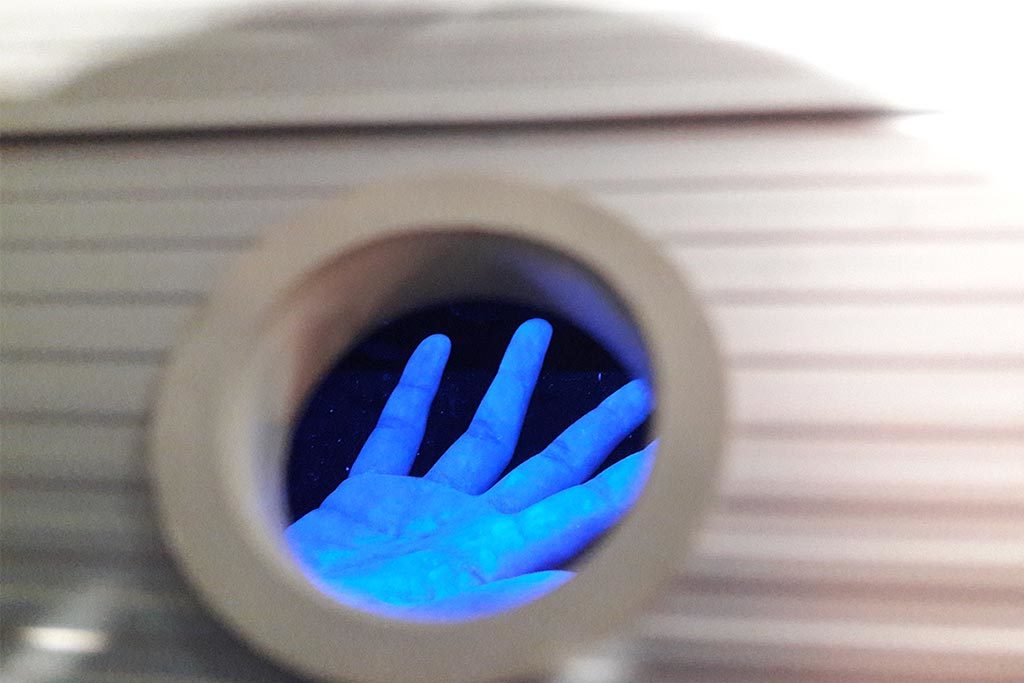 Eine Hand unter Schwarzlicht nach der Desinfektion: Nur die leuchtenden Stellen sind wirklich frei von Bakterien.