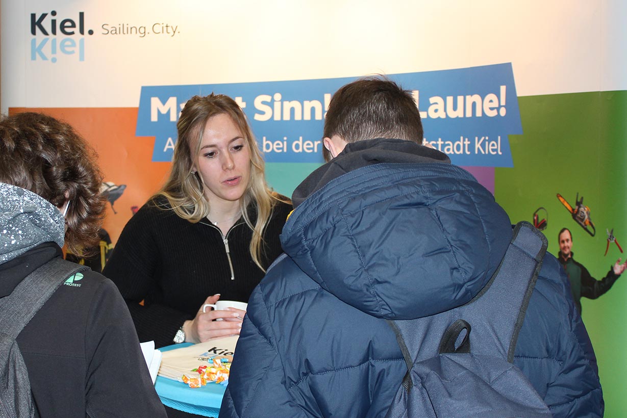 Eine Frau redet mit zwei Schülern.