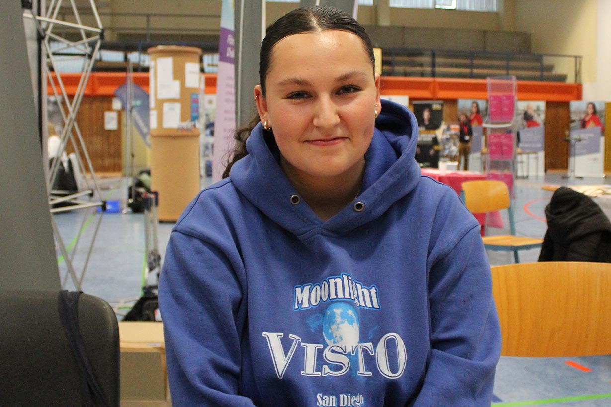 Ein Mädchen in blauem Pullover.