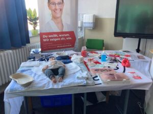 auf eine Tisch liegen verschiedene Utensilien, wie eine Baby Puppe 