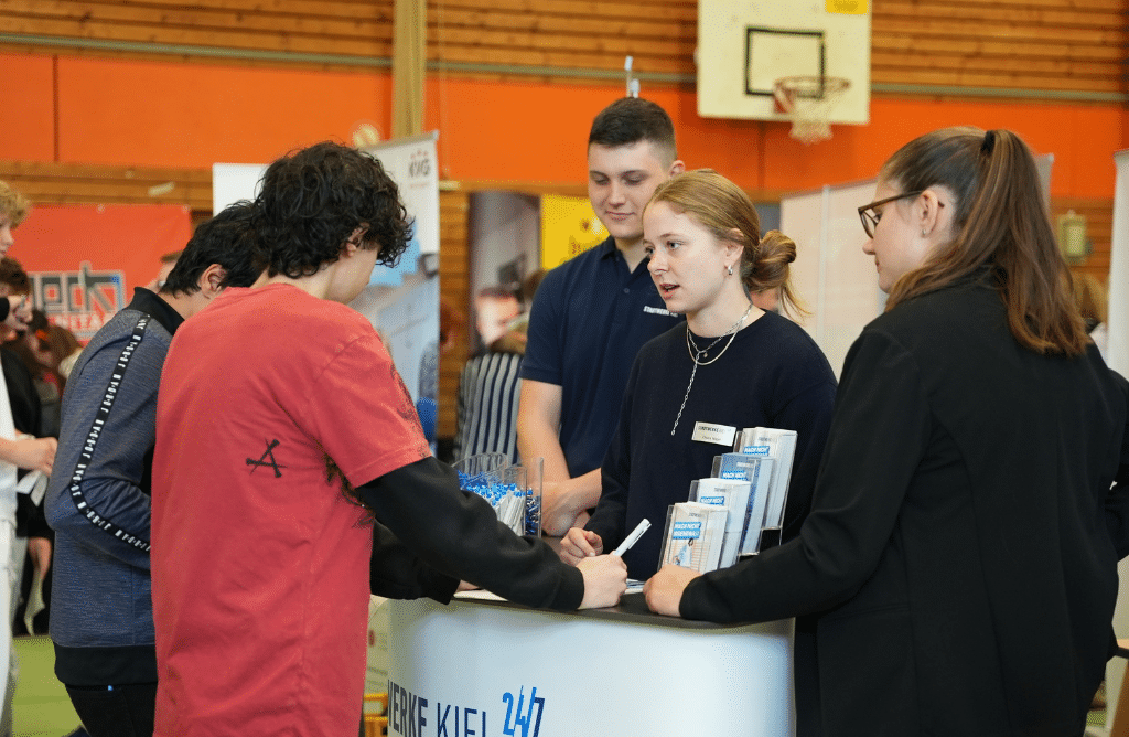 Chiara Nagel, Ausbildungsleiterin der Stadtwerke Kiel (2. v. r.) ist zufrieden mit dem Andrang der Schülerinnen und Schüler am Stand.